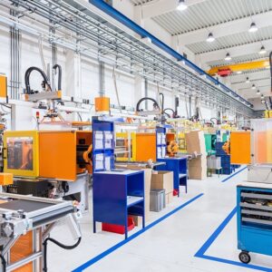 Horizontal image of huge new modern factory with robots and machines producing industrial plastic pieces and equipment. Futuristic machines having the monopole of all work, taking the place of human work.